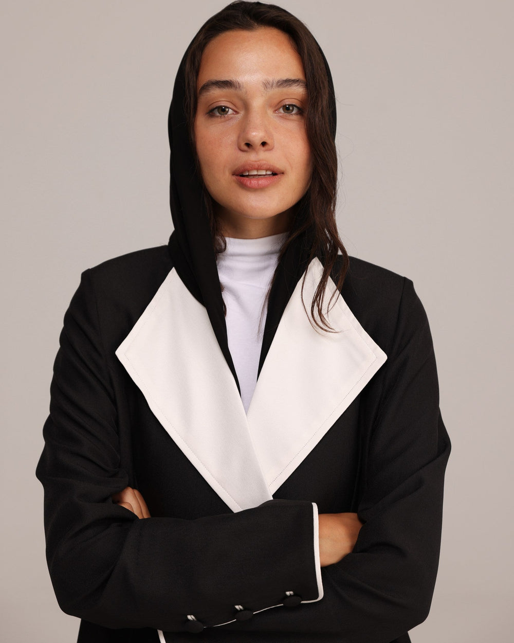 Person wearing a black and white outfit with a plain background